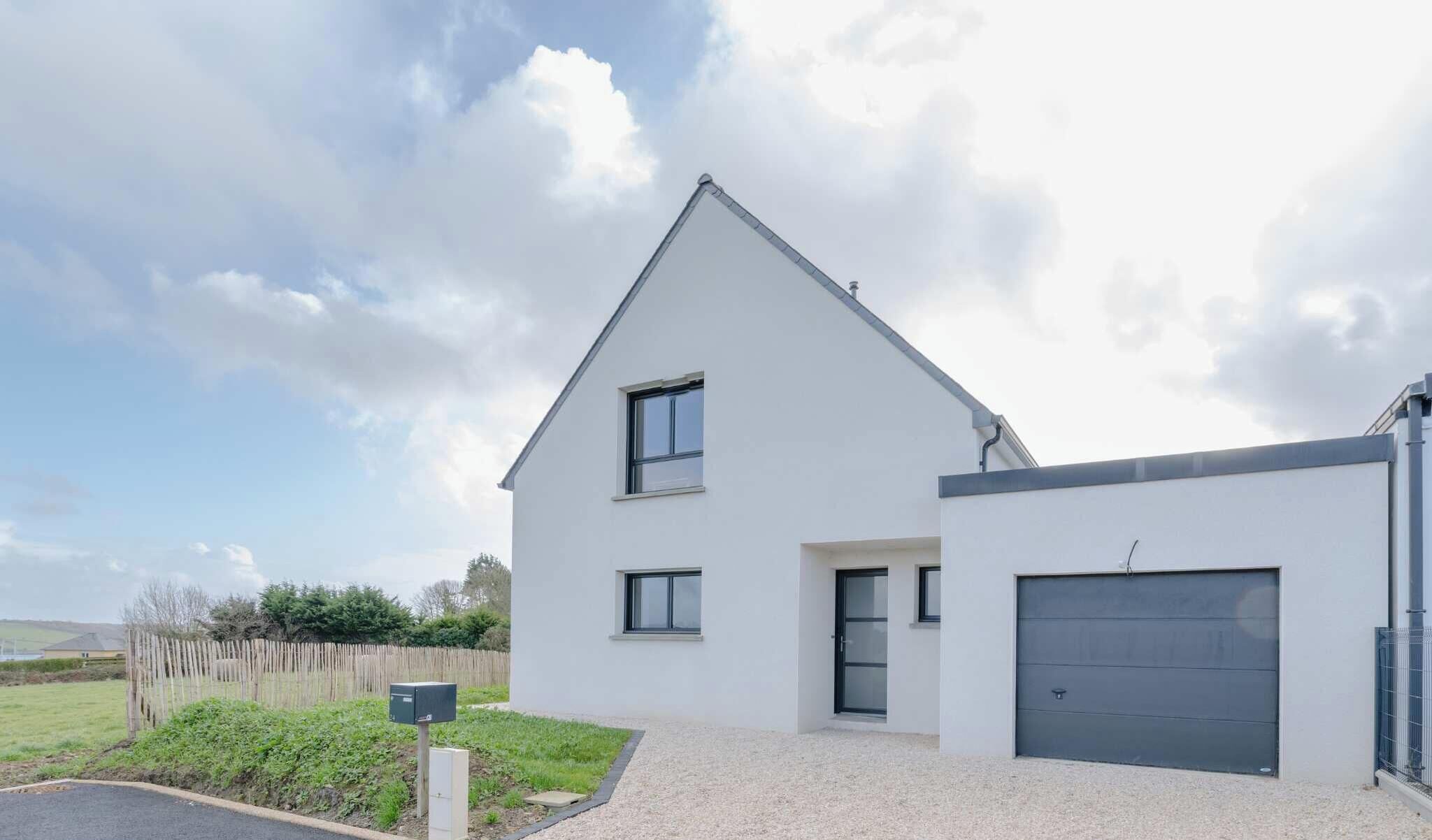 A modern two-story house with a garage, a small front porch, and a mailbox.