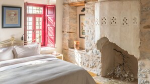 Ein Schlafzimmer mit Stehwand, einem Bett, einer roten Tür und einem weißen Schrank.
