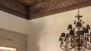 Ein Zimmer mit Schachbrettmuster-Boden, einem Chandelier, einem Kamin und einem großen abstrakten Gemälde.