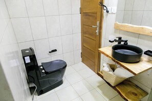 Een douche, handdoeken, zeep, toiletpapier