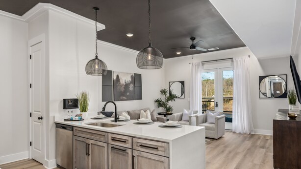 A modern kitchen with a central island, pendant lights, and a view to a balcony. - 2 Bedroom, Main Level (Helena)