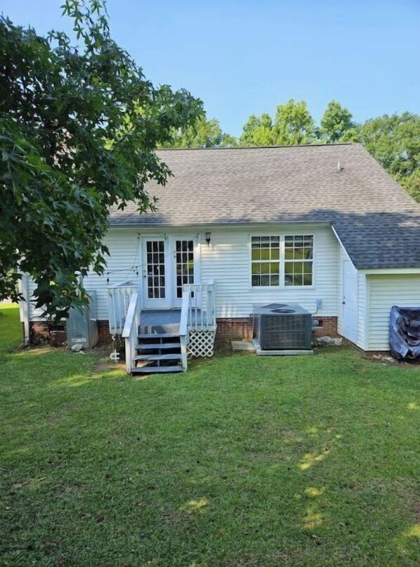 A single-story house with a front porch, a small deck, and a covered outdoor area.