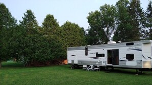 A white motorhome with a Chevrolet logo parked on a grassy field.