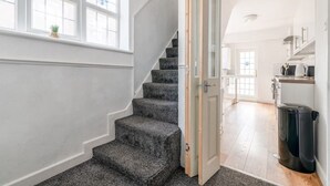 A staircase with carpeted steps leading to a room with a white door. - 3-Bed House Near Lakeside Mall | Free Parking




















 (Essex)