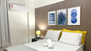 Una habitación de hotel con una cama, una mesita de noche, una lámpara y decoración en la pared.