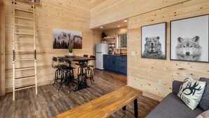 A wooden interior with a dining area, kitchen, and seating area.