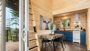 Ein Holzinterieur mit einem Esstisch, Stühlen, einem Herd und einem Bild eines Elchs.