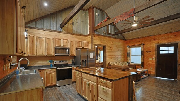Una cocina amplia con armarios de madera, una isla central y un rincón comedor con sofá.