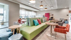 Ein stilvoller Lounge-Bereich mit einem grünen Sofa, mehreren Tischen und Stühlen.