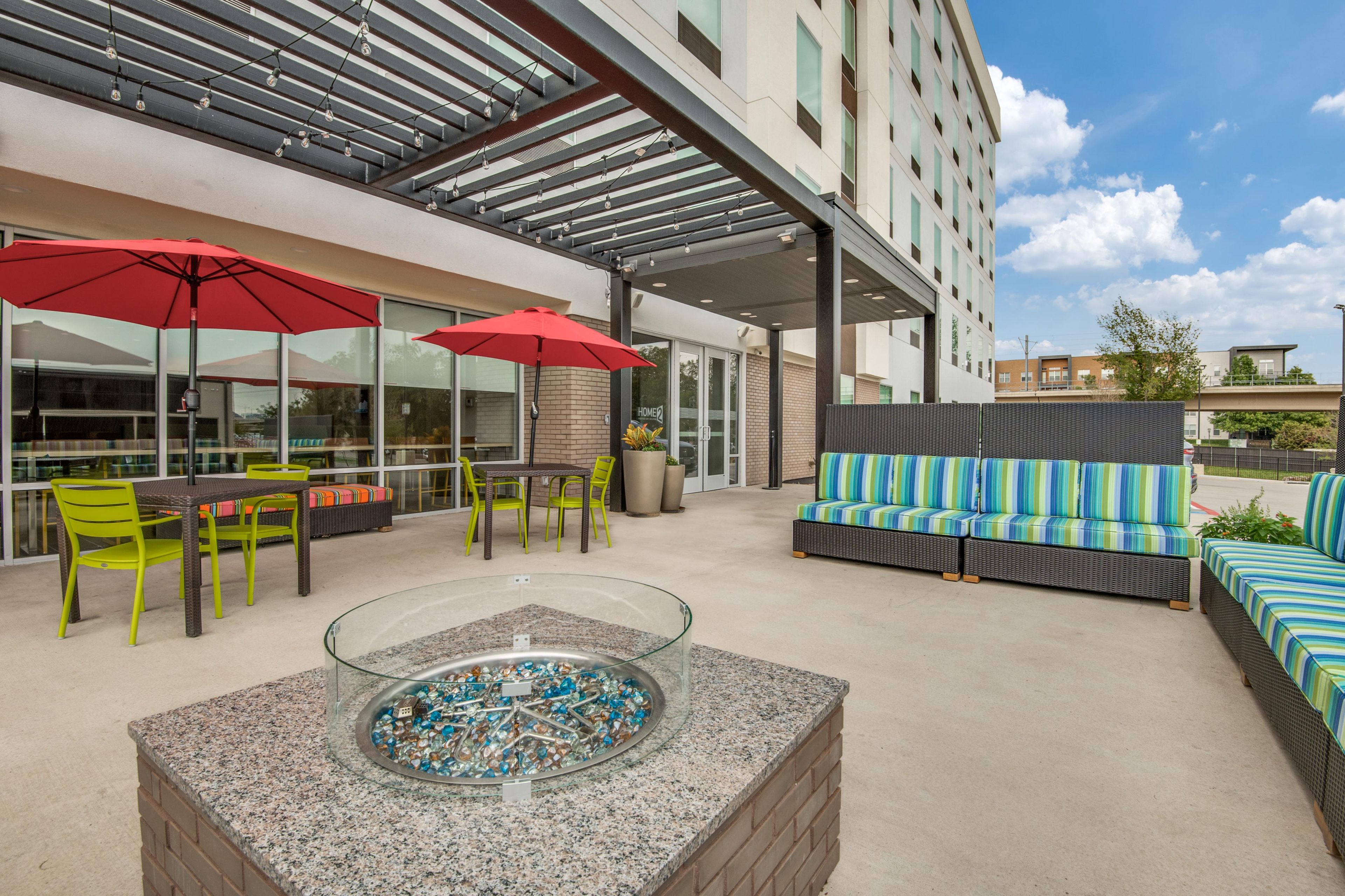 An outdoor seating area with tables, chairs, and a fire pit.