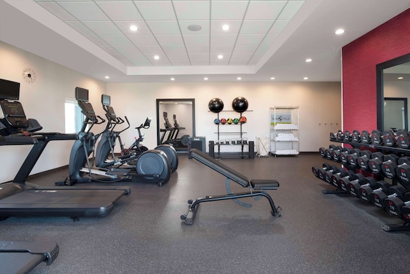A gym with treadmills, elliptical machines, a bench, and a rack of dumbbells. - Home2 Suites By Hilton Albuquerque Airport (Albuquerque)