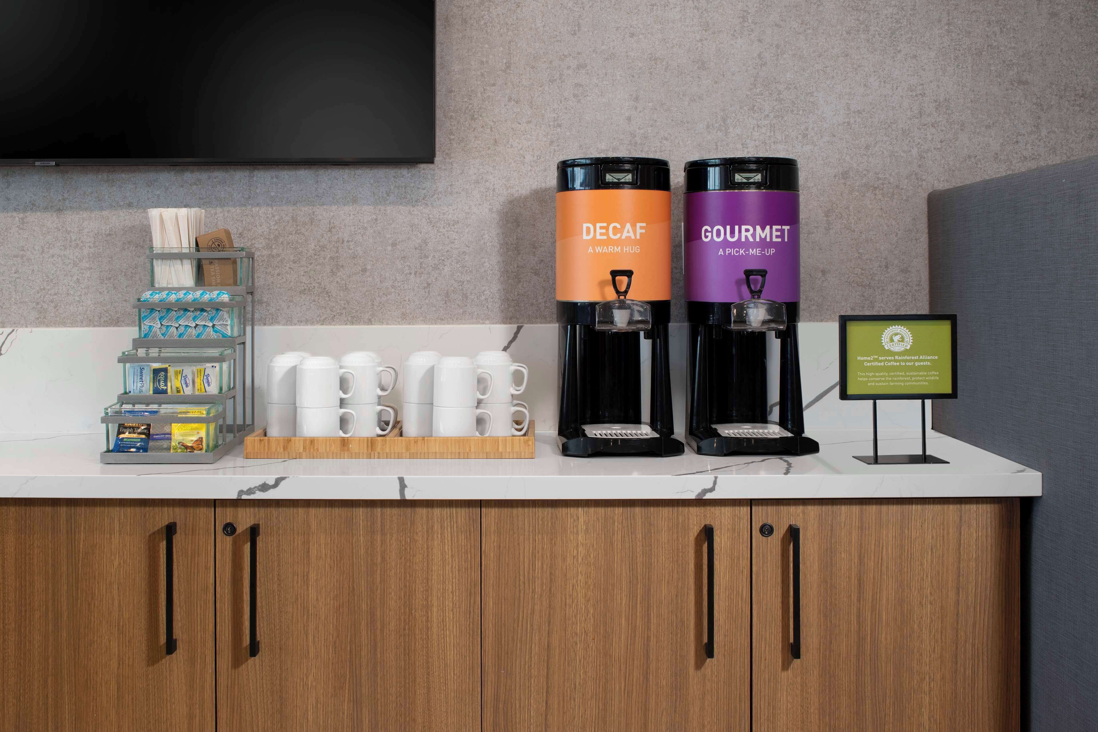 Ein Kaffee-Bereich mit zwei Kaffeeautomaten, beschriftet mit 'Decaf' und 'Gourmet'.
