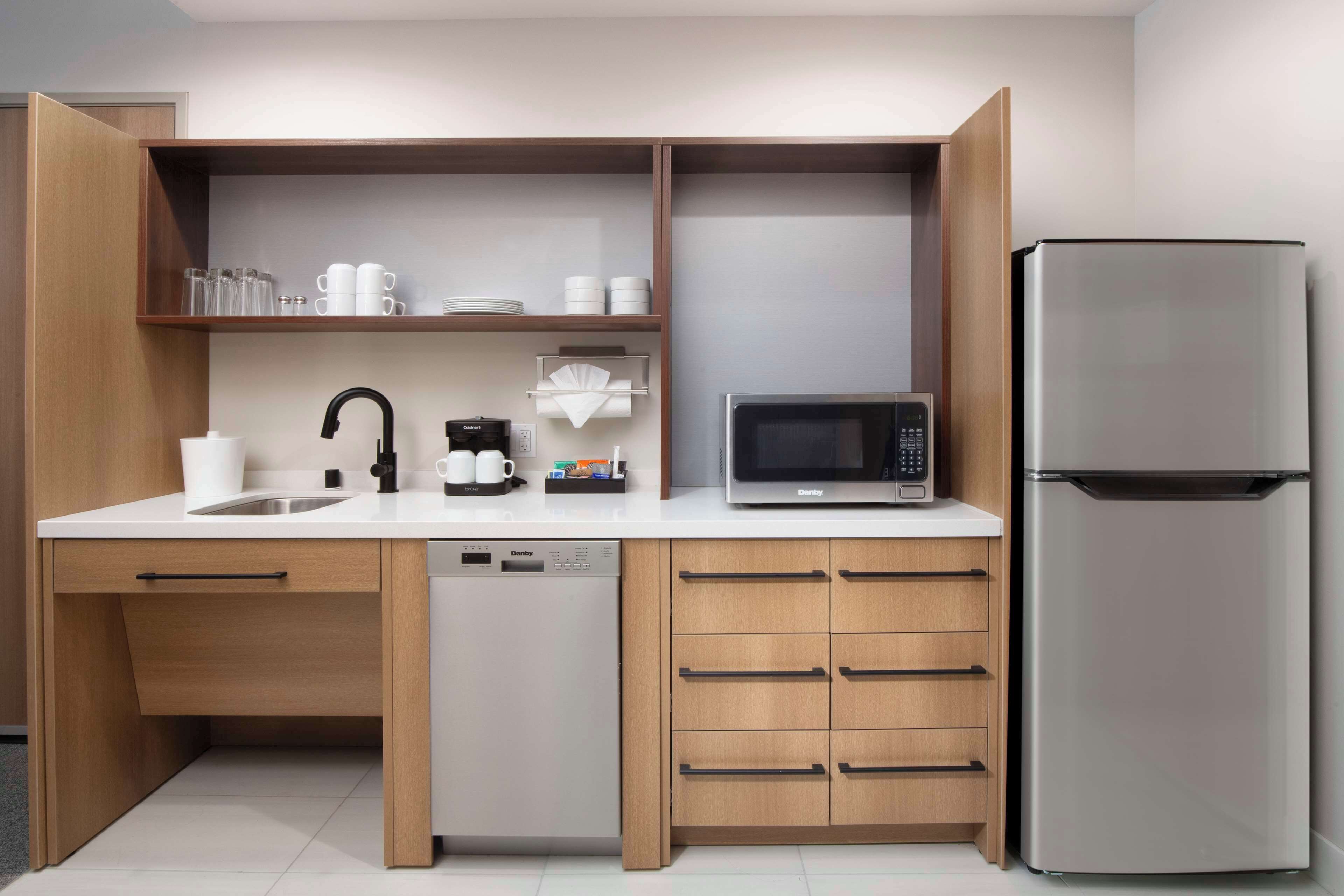 A compact kitchen with a dishwasher, a microwave, and a refrigerator.