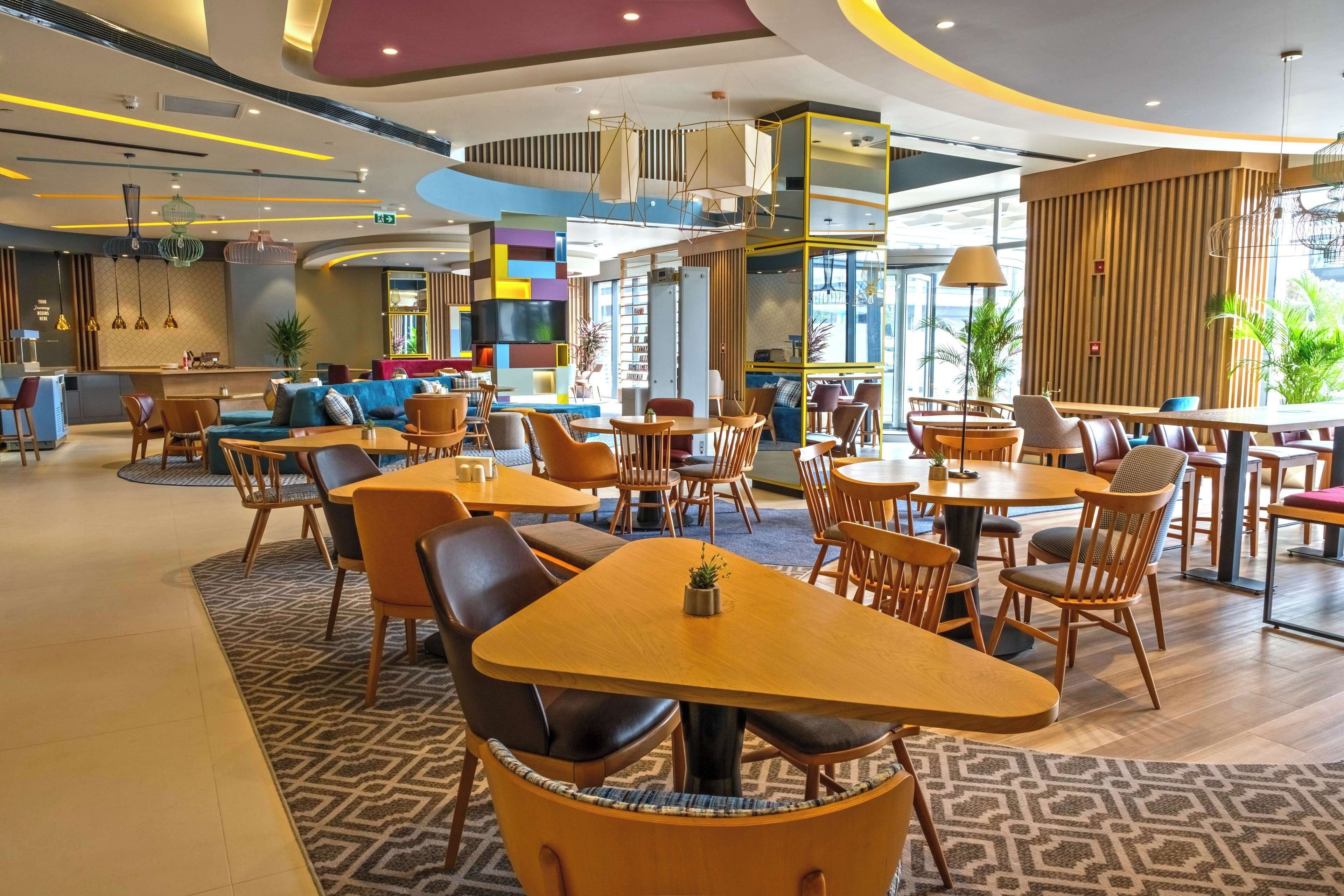 Un restaurante moderno con mesas redondas y asientos cómodos.