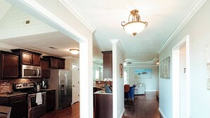Una cocina amplia con electrodomésticos modernos, una isla central y un pasillo que conduce a un comedor.