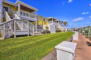 Stunning coastal buildings with balconies and staircases, set amidst a beautifully manicured lawn.