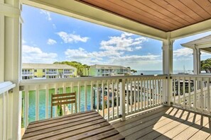 Relax on the ocean-view deck with a bench and table, surrounded by a covered area with a wooden ceiling.