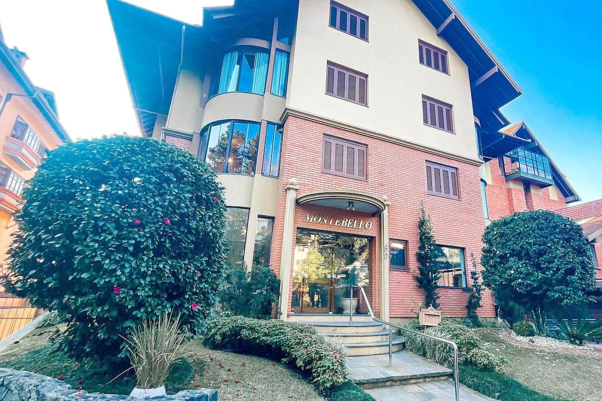 Ein Hotel mit moderner Fassade, einem gut sichtbaren Eingang und einem gepflegten Garten.