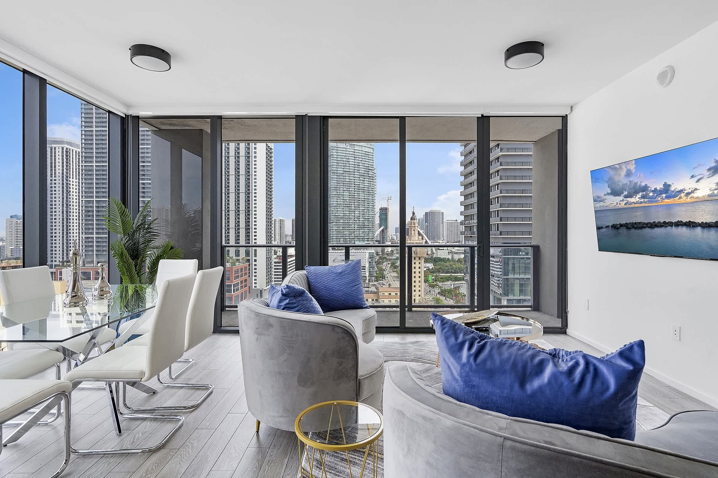 A modern living room with a city view, large windows, and contemporary furniture.