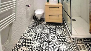 A bathroom with a shower, toilet, and sink.