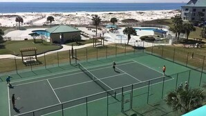 En tennisbana med utsikt över stranden och havet.
