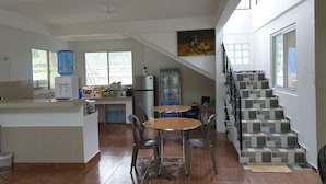 A spacious kitchen with a dining area, a water dispenser, and a refrigerator. - Hotel Pentaqua (Irosin)