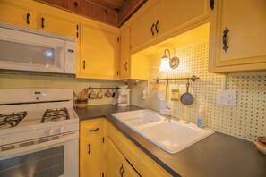 Eenvoudig huisje | Privékeuken | Een waterkoker, kookgerei, borden en bestek