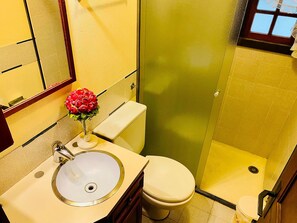 A bathroom with a sink, toilet, and shower. - EXCELENTE OPÇAO - 03 quadras RUA COBERTA (Gramado)