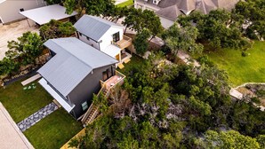 An aerial view of a residential area with modern houses, a large barn, and a well-maintained lawn.