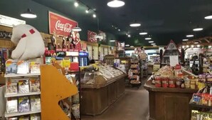 En mataffärs interiör med olika sorters matvaror och en stor Coca-Cola-skylt.
