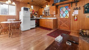 Ein Holzblockhaus-Interieur mit Küche, Essbereich und Kamin.