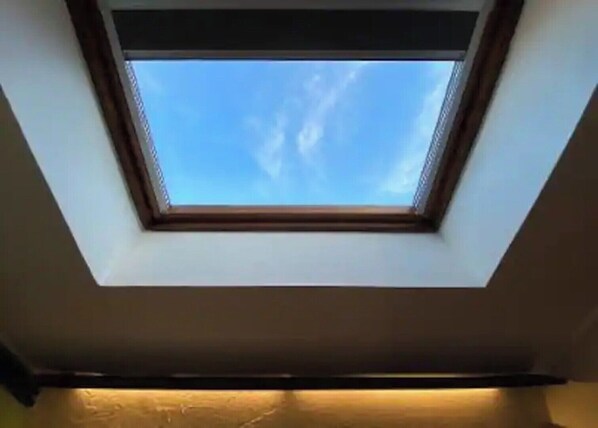 A skylight with a clear blue sky view.