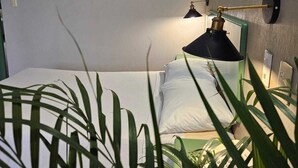 A bedroom with a bed, a bedside lamp, and three abstract paintings on the wall. - Hotel Punto Poza Rica (Poza Rica)