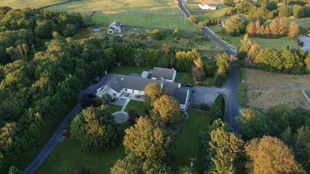 An aerial view of a residential area with houses, a road, and a lake. - Fisherman's Lodge | Lough Corrib | 3 Bed | Galway Lakeside | Lake Access (County)