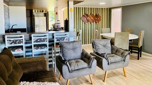 Un salon moderne avec un coin repas, et une cuisine en arrière-plan.