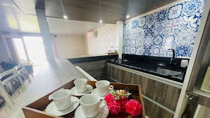 Une cuisine moderne avec un plateau de tasses blanches et un bouquet de fleurs.