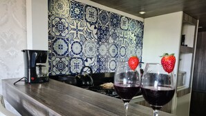 Un comptoir de cuisine avec deux verres à vin, dont l’un est décoré d’une fraise, et une machine à café.