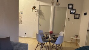 A dining area with a table and chairs, a sofa, and a chair. - 13 minutes away from quinta avenida (Q.R.)