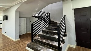 A staircase with black railings and marble steps leading to a landing.