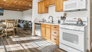 A kitchen with wooden cabinets, a white stove, and a microwave.