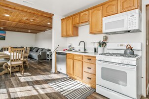 Una cocina con armarios de madera, una estufa blanca y un microondas.
