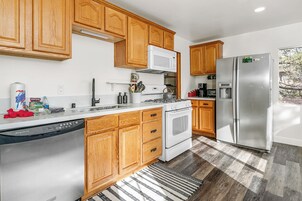 Una cocina moderna con armarios de madera, electrodomésticos de acero inoxidable y lavavajillas.
