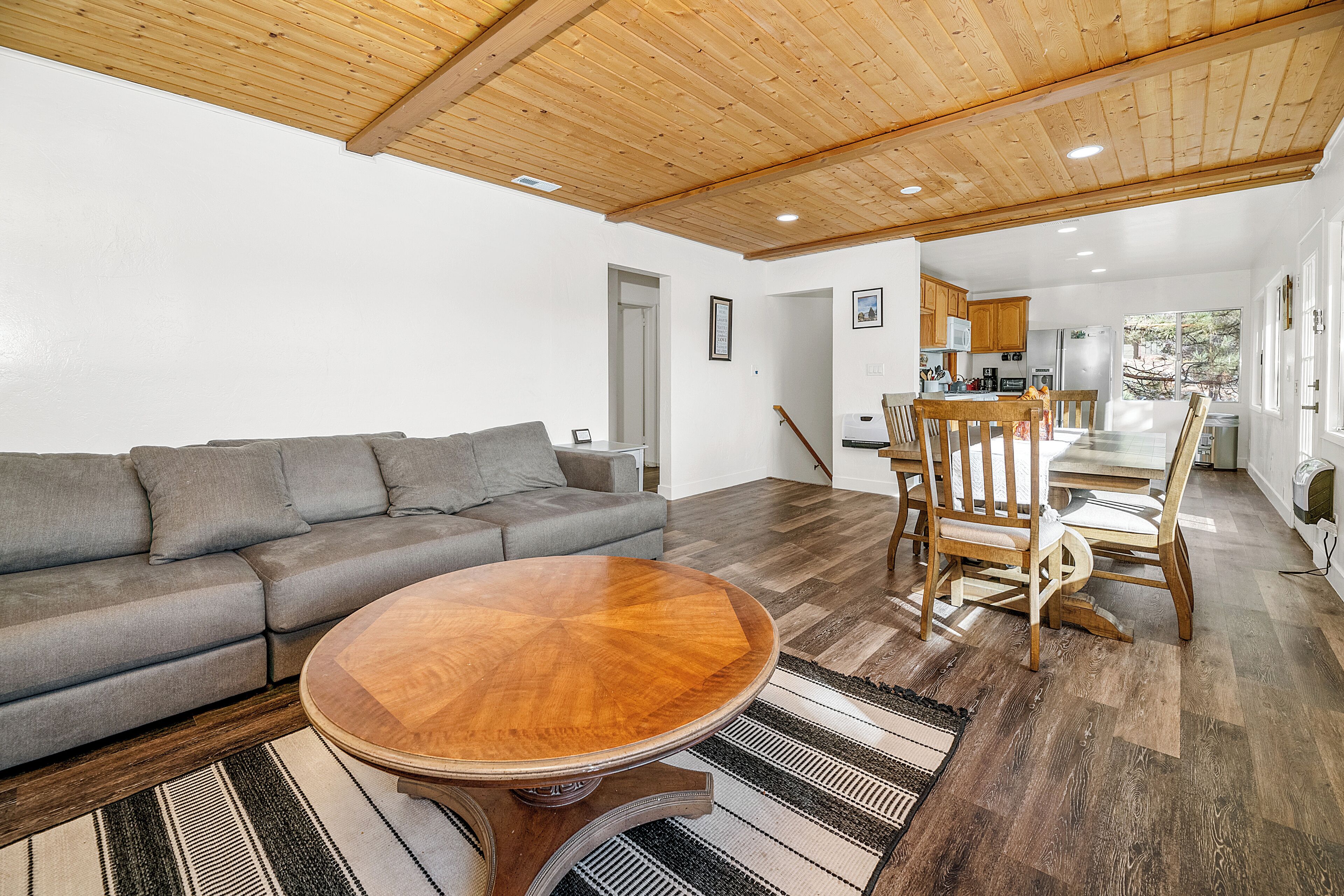 Una sala de estar con un sofá gris, una mesa de centro de madera y un tapete a rayas.