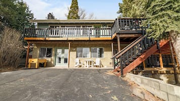A two-story building with a balcony, outdoor seating area, and a staircase leading to an upper level.