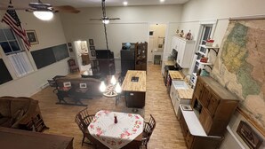 Una cocina amplia con piso de madera, un comedor con mesa y sillas, y un mapa grande en la pared.