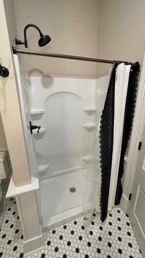 Een douche, handdoeken, zeep, toiletpapier