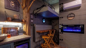 Une cuisine équipée d’un four encastré, d’une table en bois et d’un aquarium fixé au mur.