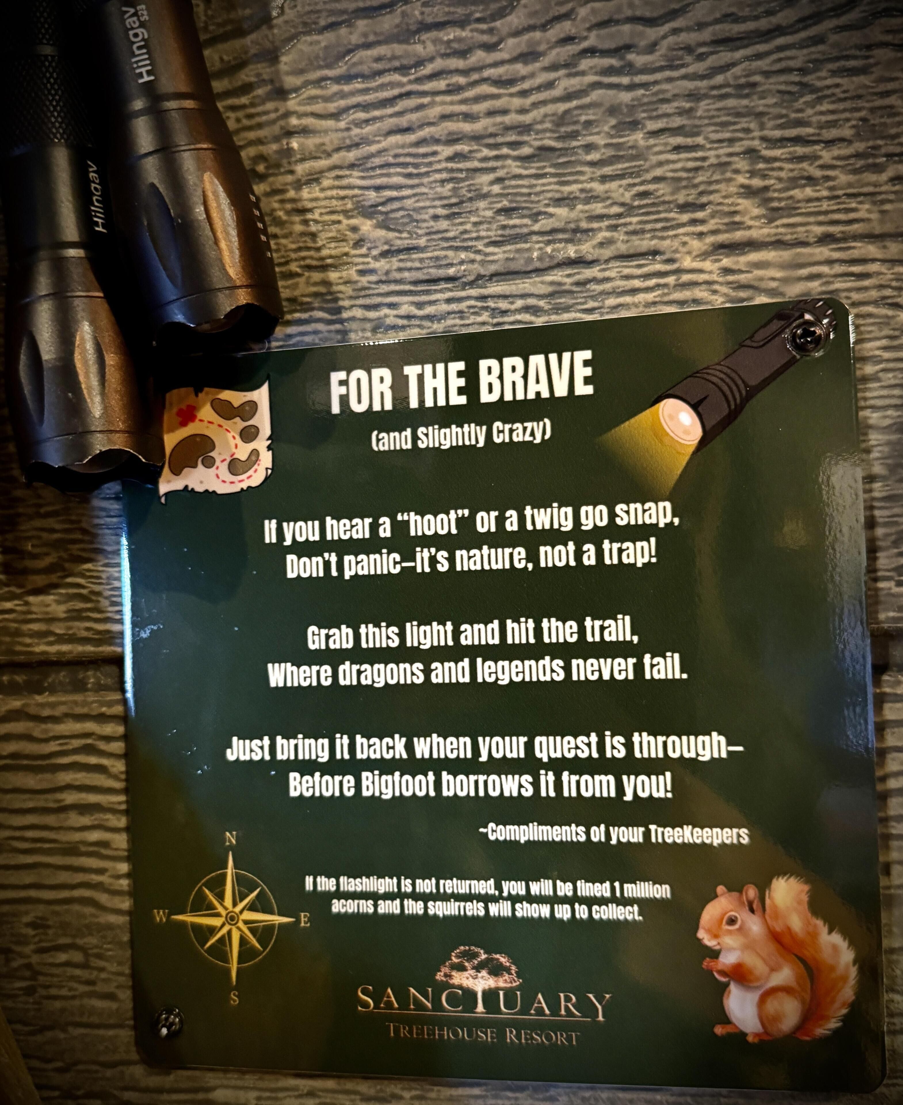 A sign with a flashlight and a compass, featuring a humorous message about nature and a warning about a fine for not returning the flashlight.