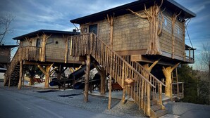 Una casa en el árbol con revestimiento de madera y una escalera.