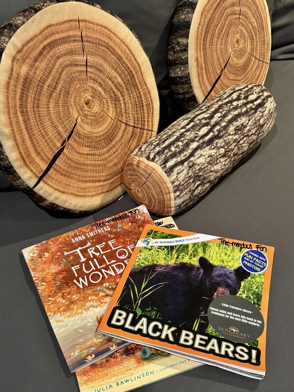 A collection of tree logs and two books titled 'Tree-Mendous Fun' and 'Black Bears!'